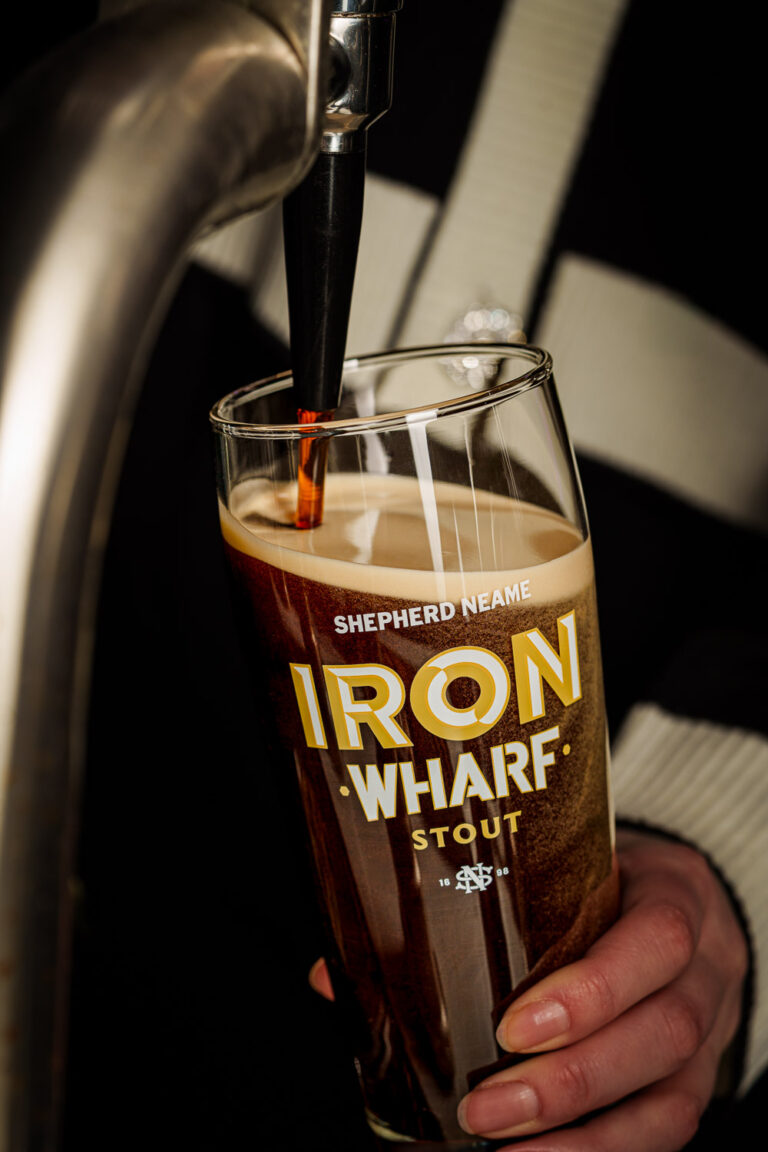 Bottle of Shepherd Neame 1698 Kentish Strong Ale on a bed of dried hops