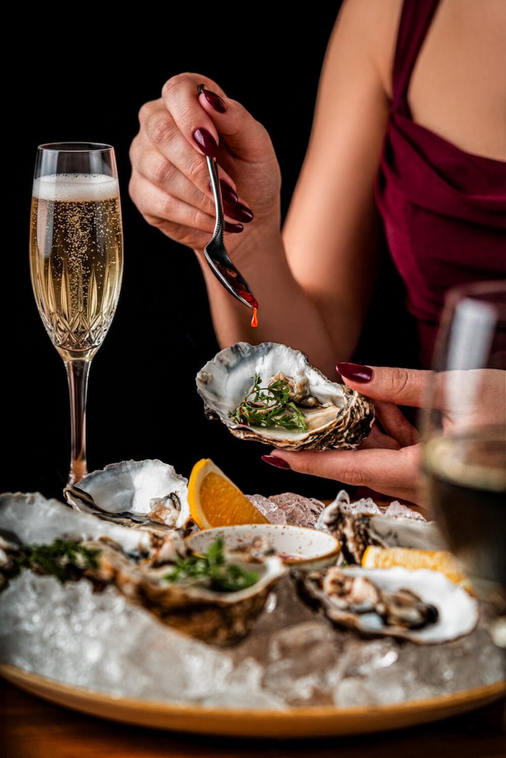 Fresh oysters on ice served with citrus and champagne in an elegant fine dining setting. Fresh oysters on ice with citrus and champagne in an elegant fine dining setting